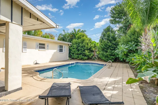 a view of a house with pool and sitting area