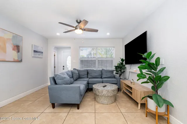a living room with furniture potted plant and a window