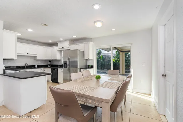 a kitchen with a dining table chairs and white appliances