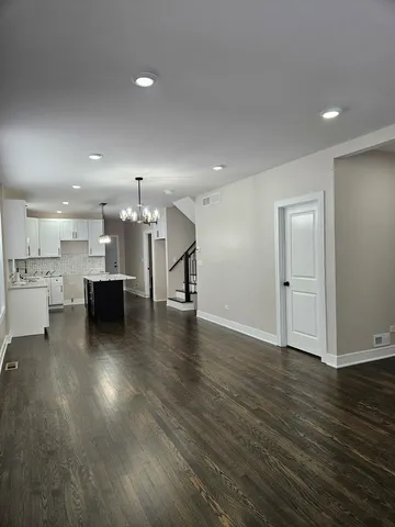 a view of a big room with wooden floor and windows