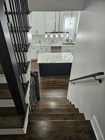 a view of entryway and kitchen with wooden floor