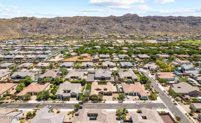 an aerial view of residential houses with outdoor space and trees