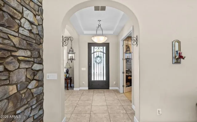a view of a hallway with windows and chandelier
