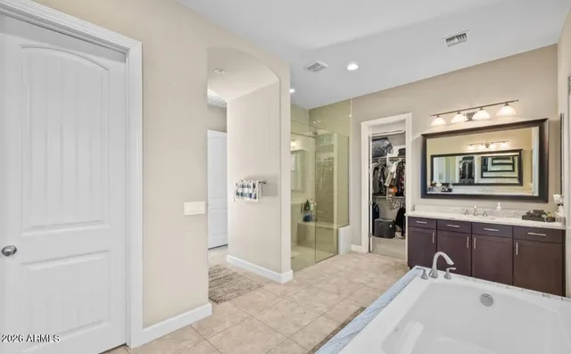 a spacious bathroom with a shower sink and mirror