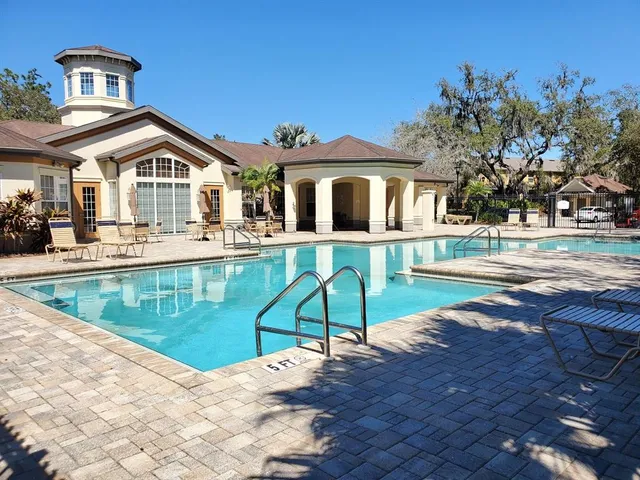 a view of a house with pool and chairs
