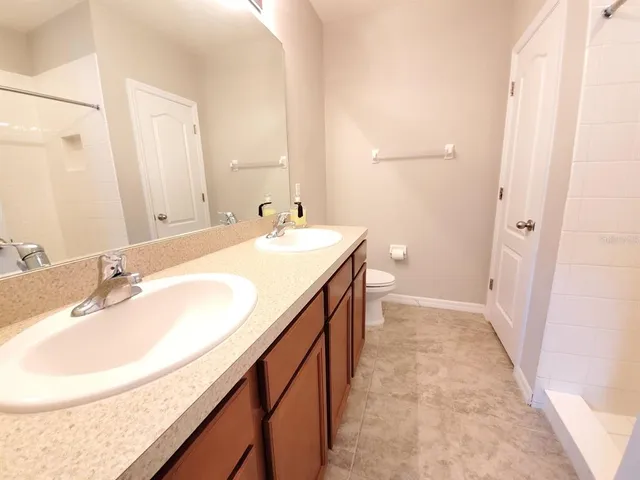 a bathroom with a sink a toilet and a mirror