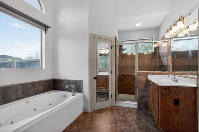 a bathroom with a tub sink and mirror