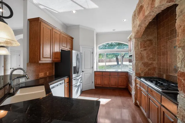 a kitchen with stainless steel appliances a stove a sink and a refrigerator