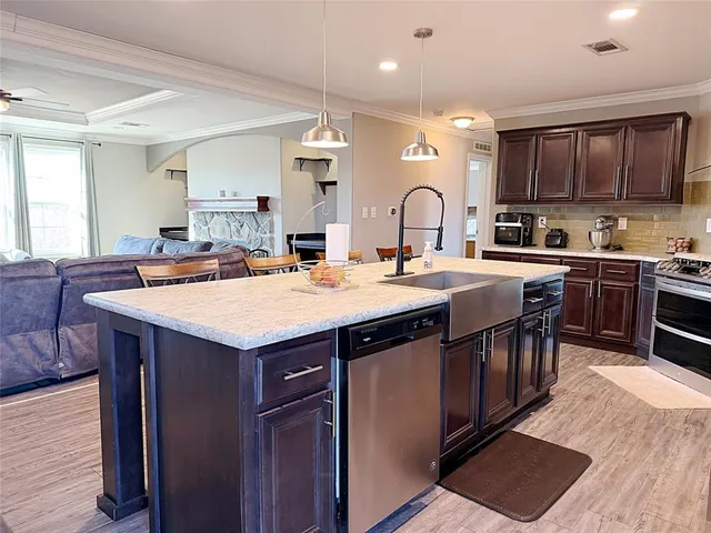 a kitchen with granite countertop a sink a stove and cabinets