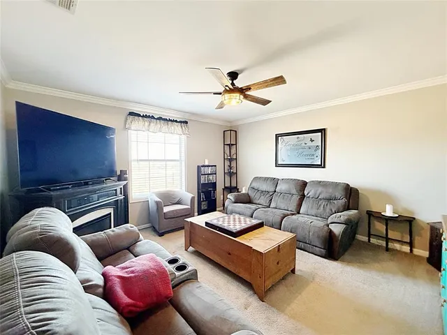 a living room with furniture ceiling fan and a window
