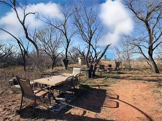 a view of a backyard with table and chairs