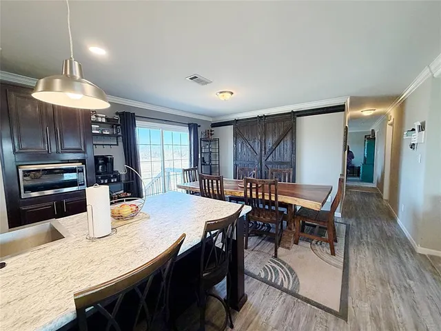 a kitchen with a dining table chairs and refrigerator