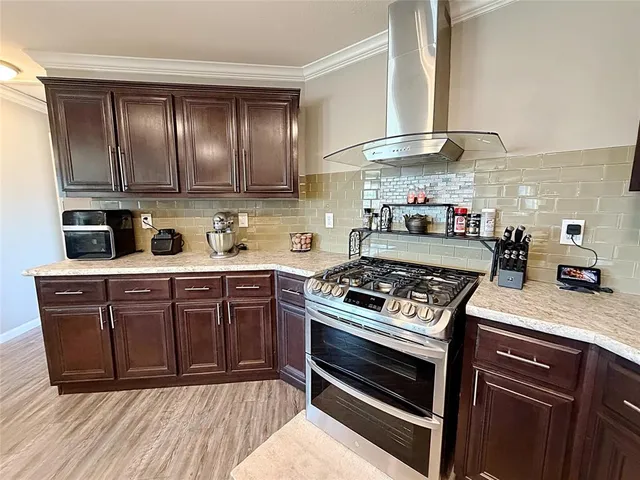 a kitchen with stainless steel appliances granite countertop a stove a sink and a refrigerator