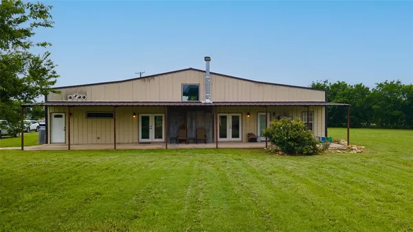 a view of a house with a yard and sitting area