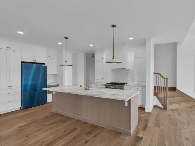 a kitchen with stainless steel appliances granite countertop a stove a sink and a refrigerator