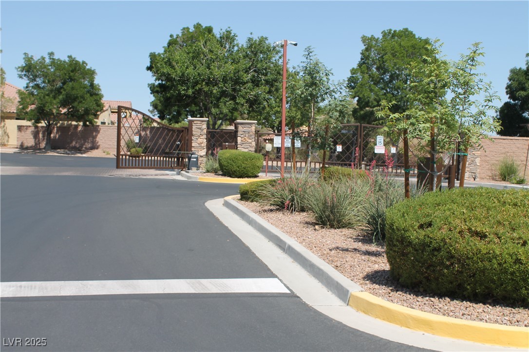 7352 Ravines Avenue Las Vegas, NV 89131 - Photo 16 of 93 View of asphalt street featuring a gated entry, curbs, and a gate