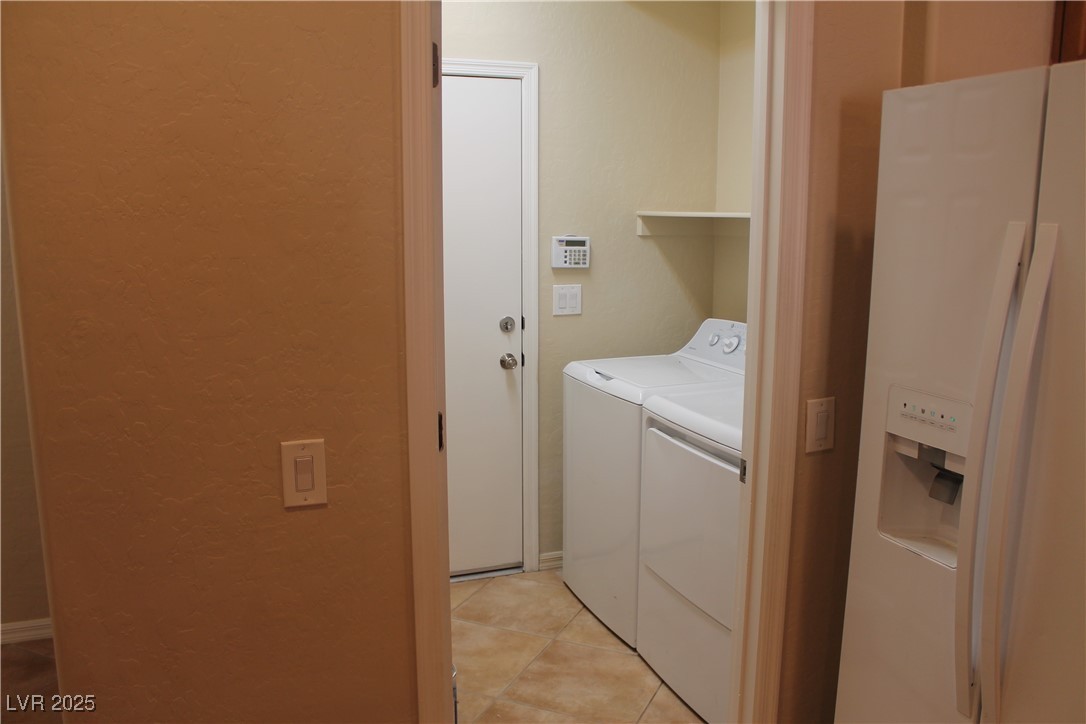 7352 Ravines Avenue Las Vegas, NV 89131 - Photo 40 of 93 Laundry room featuring light tile patterned flooring, separate washer and dryer, and a textured wall