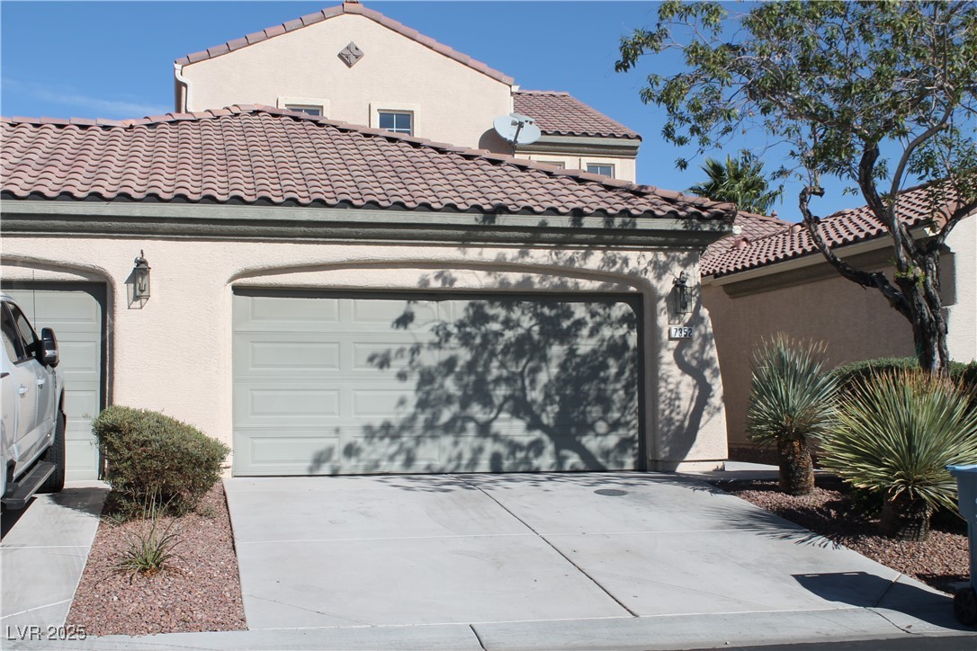 7352 Ravines Avenue Las Vegas, NV 89131 - Photo 46 of 93 View of front facade with stucco siding, concrete driveway, a tiled roof, and a garage