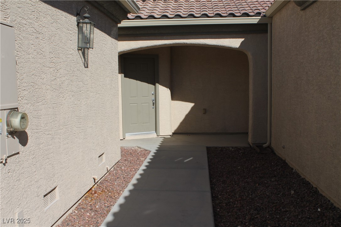 7352 Ravines Avenue Las Vegas, NV 89131 - Photo 48 of 93 Doorway to property featuring a tile roof, stucco siding, and crawl space