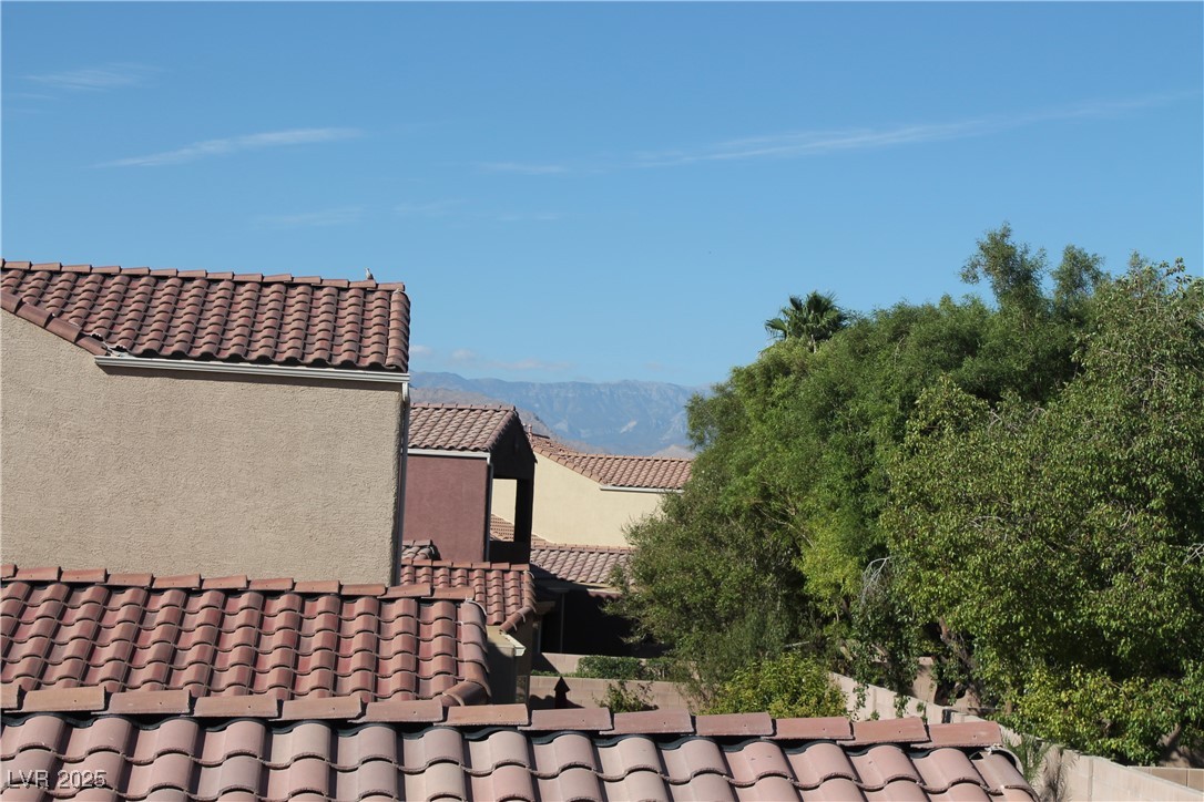 7352 Ravines Avenue Las Vegas, NV 89131 - Photo 50 of 93 View of side of property featuring a tile roof, a mountain view, and stucco siding