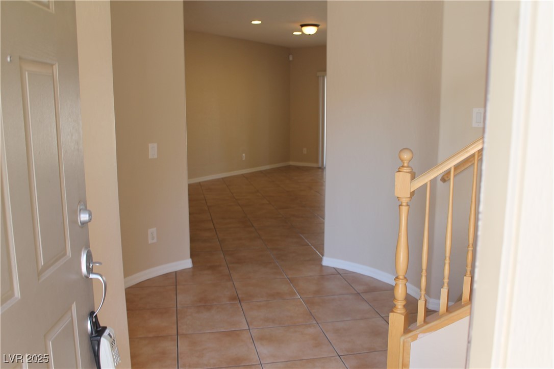 7352 Ravines Avenue Las Vegas, NV 89131 - Photo 5 of 93 Hallway featuring light tile patterned flooring, stairway, and recessed lighting