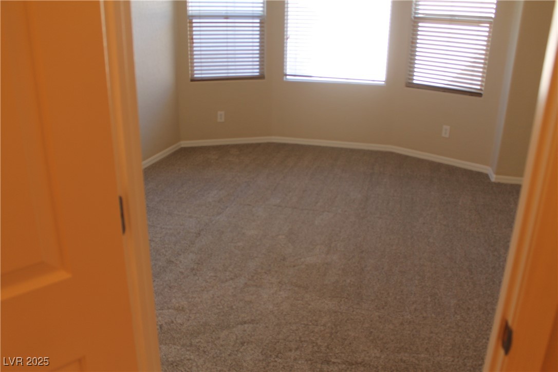 7352 Ravines Avenue Las Vegas, NV 89131 - Photo 84 of 93 Empty room featuring light colored carpet and baseboards