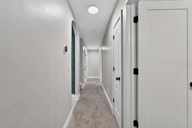 a view of an empty room with chandelier fan