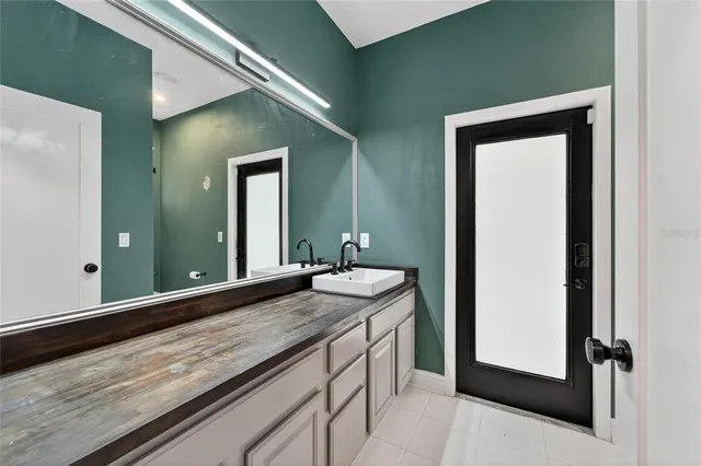 a bathroom with a granite countertop sink and mirror