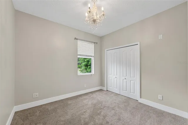 a view of a hallway with a chandelier fan and windows