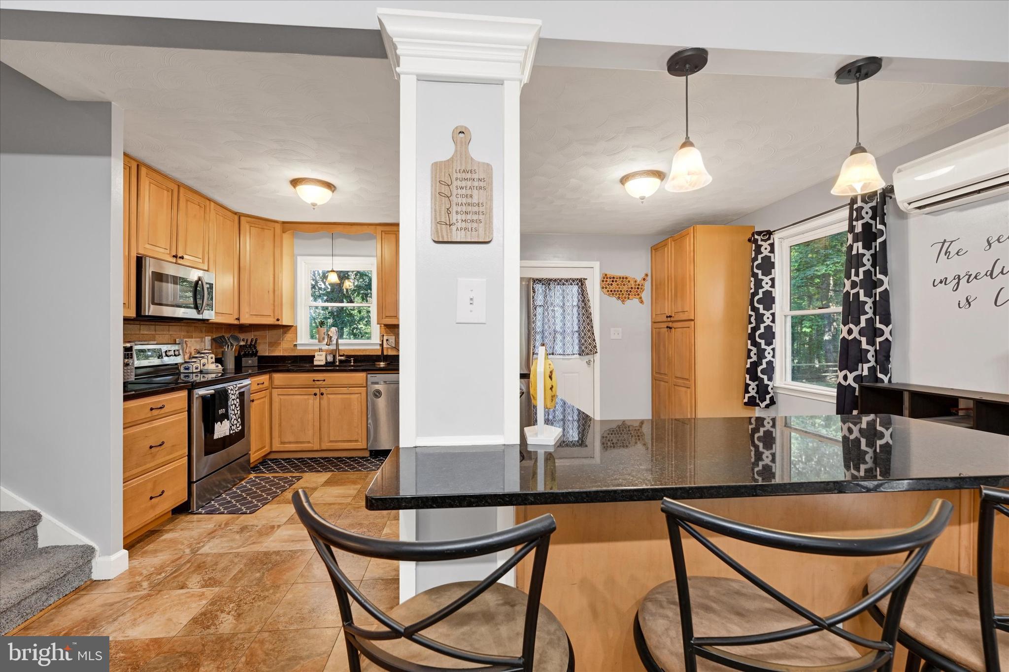 20 Houcksville Road South Hampstead, MD 21074 - Photo 11 of 37 a kitchen with stainless steel appliances kitchen island granite countertop a dining table chairs and a refrigerator