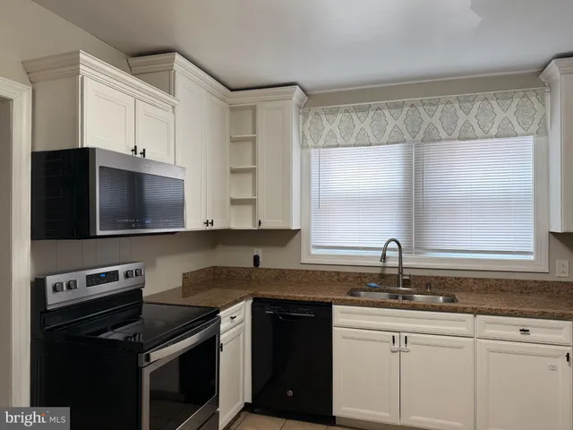 a kitchen with a sink stove top oven and cabinets