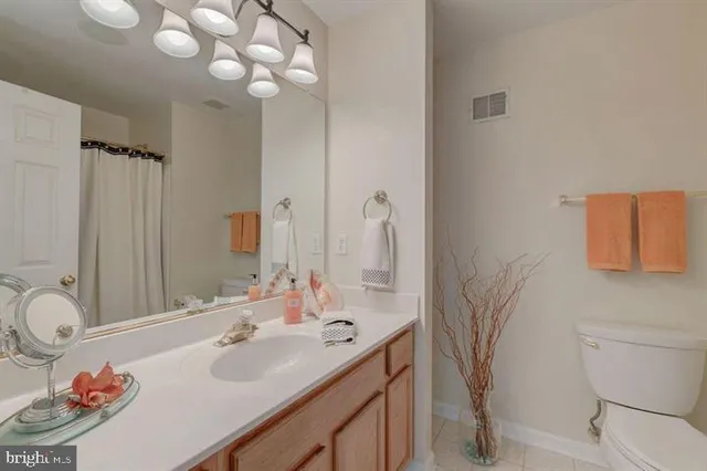 a bathroom with a sink vanity granite and toilet