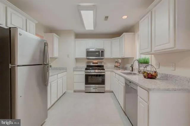 a kitchen with refrigerator a stove a sink and cabinets