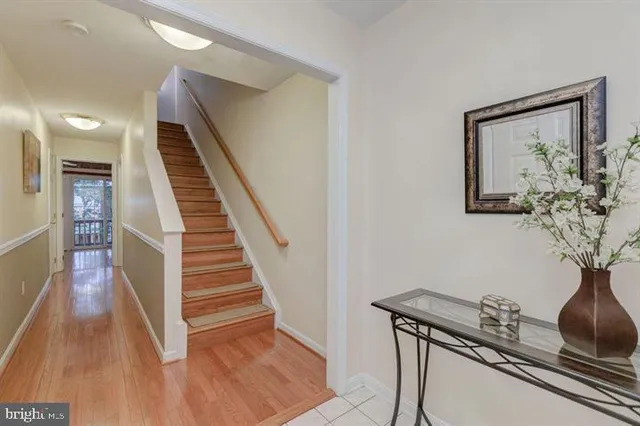 a view of a hallway with wooden floor and stairs