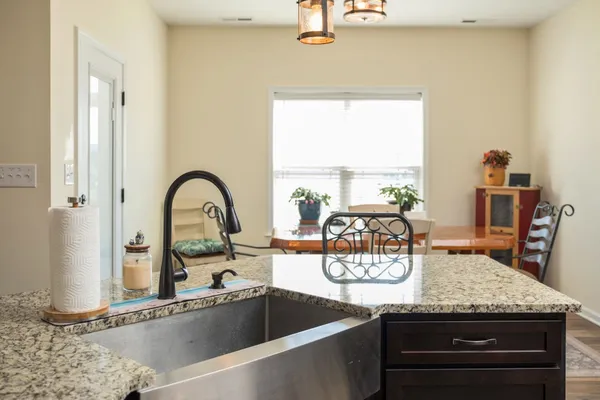 a kitchen with a sink and a stove with a dining table