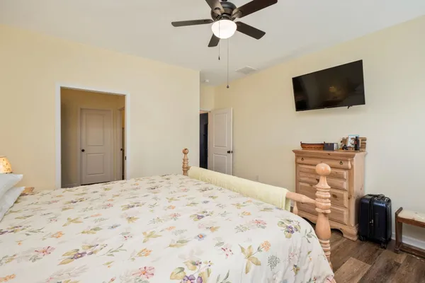 a bedroom with a bed and a flat tv screen on dresser