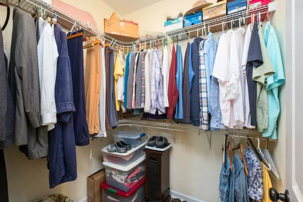a view of walk in closet with clothes