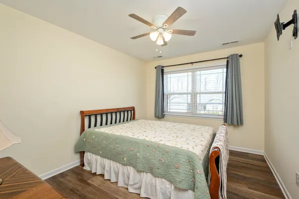 a bedroom with a bed next to a window with a chandelier