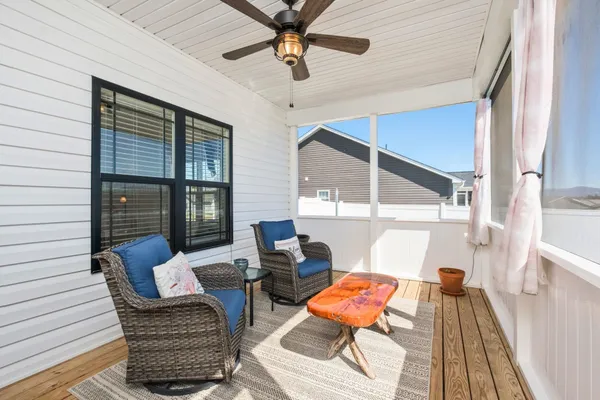 a balcony with wooden floor and outdoor seating