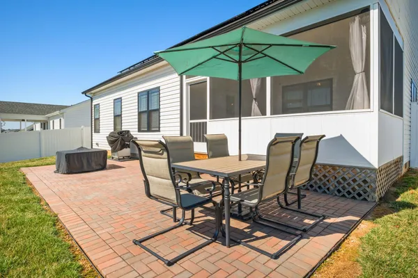 a view of a patio with a dining table and chairs under an umbrella