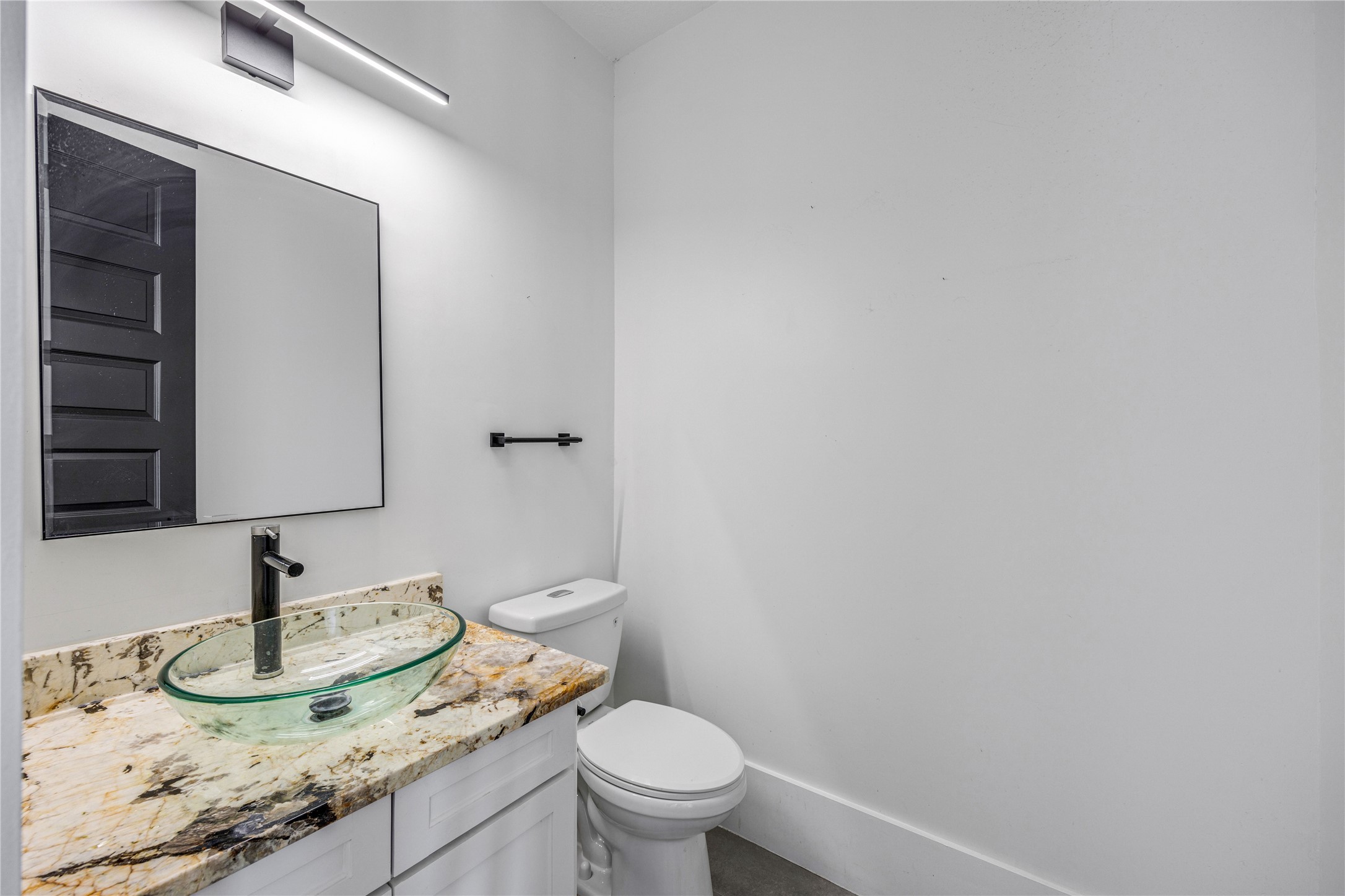 15015 House Road Cypress, TX 77433 - Photo 24 of 50 This bathroom features a modern design with a vessel sink on a marble countertop, sleek faucet, and minimalist lighting, offering a clean and stylish look.