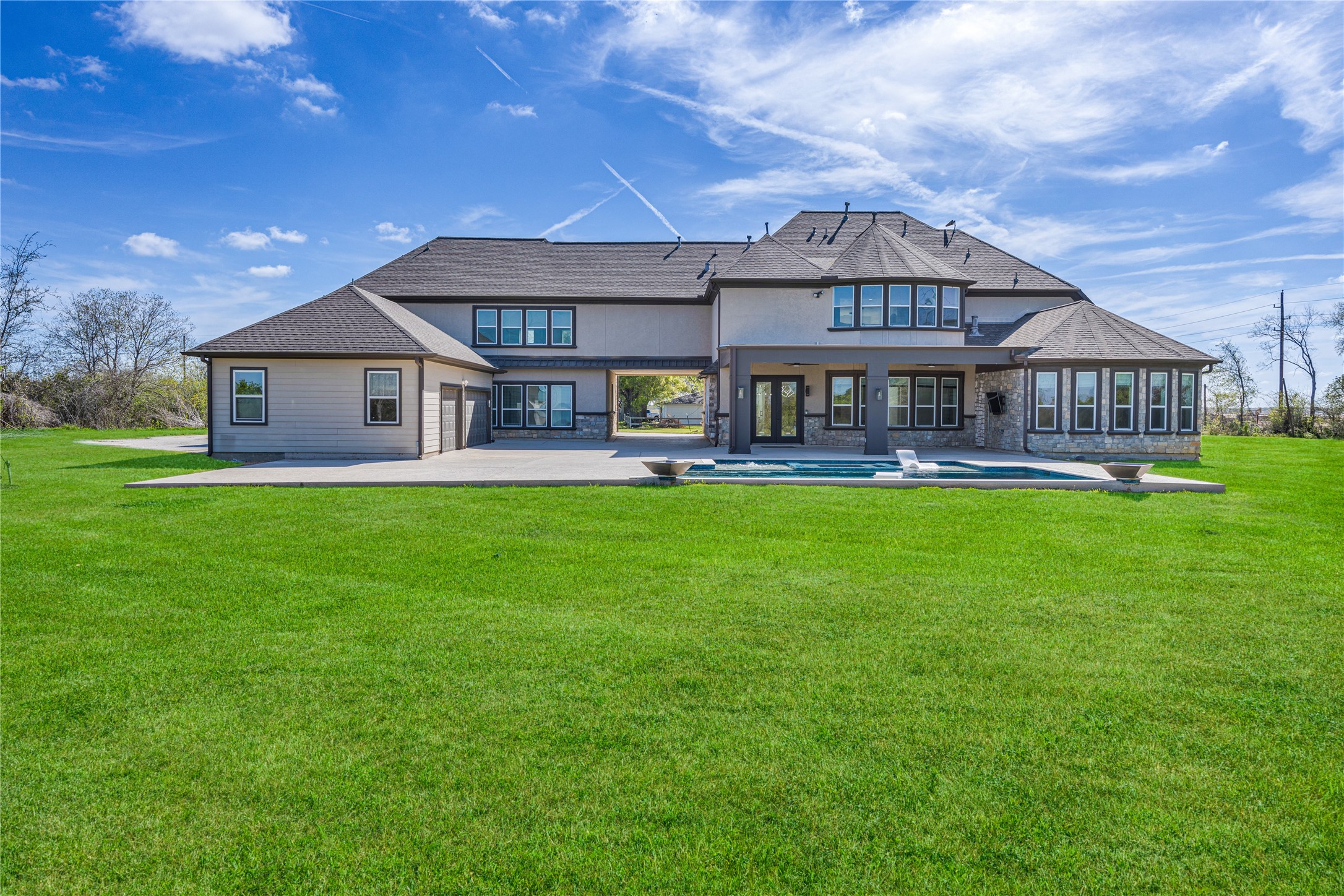 15015 House Road Cypress, TX 77433 - Photo 5 of 50 This is a spacious, modern two-story home with a large backyard, featuring a well-maintained lawn and a swimming pool. The exterior has a combination of stone and siding, and numerous windows offer plenty of natural light. Perfect for family living and entertaining.