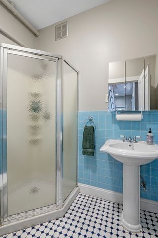 a view of a hallway with wooden floor and a chandelier