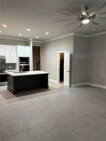 a view of kitchen with kitchen island microwave and cabinets