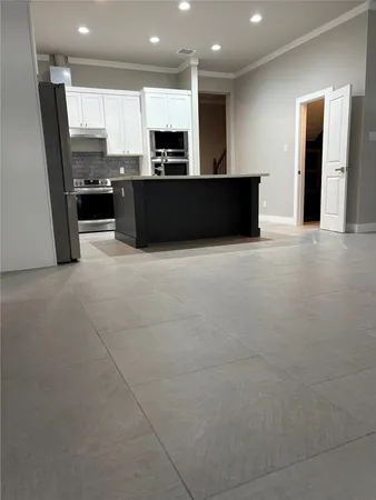 a large kitchen with stainless steel appliances kitchen island granite countertop a refrigerator and a stove top oven