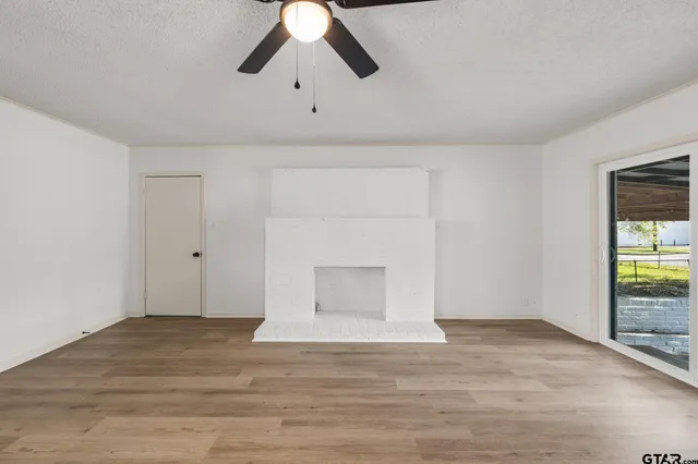 a view of an empty room and window with wooden floor