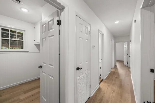 a view of a hallway with wooden floor and closet