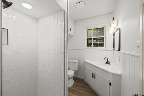 a bathroom with a sink a toilet and shower