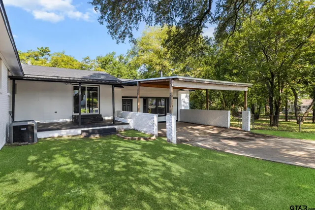 a view of a house with a yard and sitting area