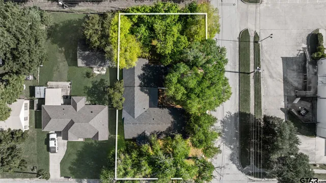 an aerial view of residential houses with outdoor space and trees